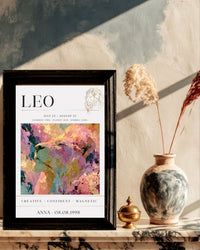 Plakat zodiakalny Lew A3 w czarnej ramie na marmurowej komodzie — personalizacja imieniem i datą urodzenia